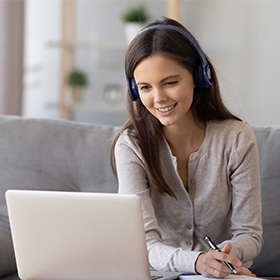 Woman with headphones pen looking at notepad